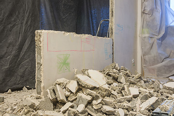 Image showing Broken pieces of the wall lie near the wall being dismantled