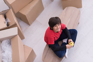Image showing boy sitting on the table with cardboard boxes around him top vie