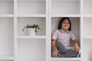 Image showing young boy posing on a shelf