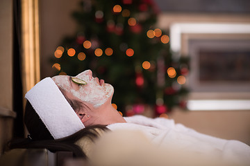 Image showing woman is getting facial clay mask at spa