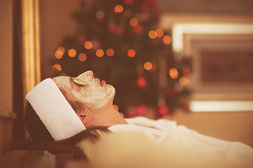 Image showing woman is getting facial clay mask at spa