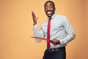 Image showing Attractive standing Afro-American businessman writing notes