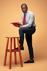 Image showing Attractive standing Afro-American businessman writing notes