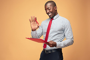 Image showing Attractive standing Afro-American businessman writing notes