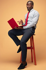 Image showing Handsome Afro American man sitting and using a laptop