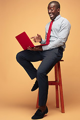 Image showing Handsome Afro American man sitting and using a laptop