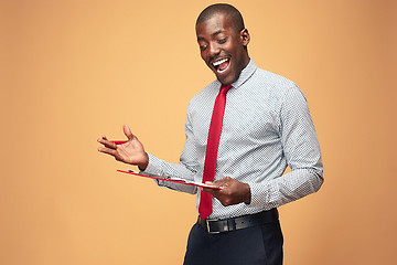 Image showing Attractive standing Afro-American businessman writing notes