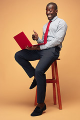 Image showing Handsome Afro American man sitting and using a laptop