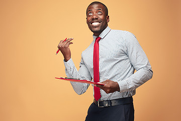 Image showing Attractive standing Afro-American businessman writing notes