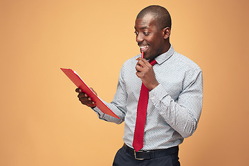 Image showing Attractive standing Afro-American businessman writing notes