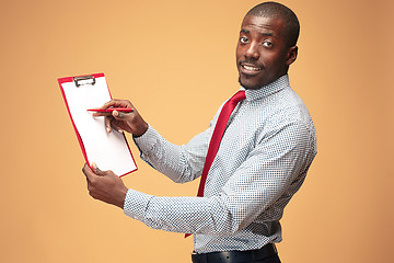 Image showing Attractive standing Afro-American businessman writing notes