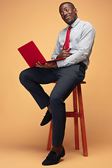 Image showing Handsome Afro American man sitting and using a laptop