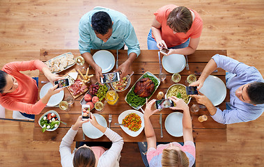 Image showing women with smartphones eating food at table