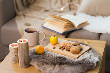 Image showing cookies, lemon tea and candles on table at home