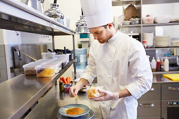 Image showing happy male chef cooking food at restaurant kitchen