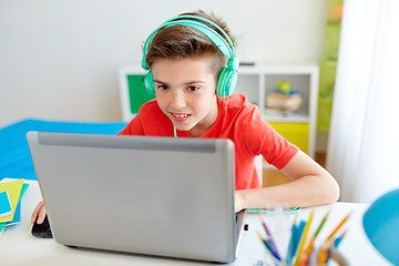 Image showing boy in headphones playing video game on laptop
