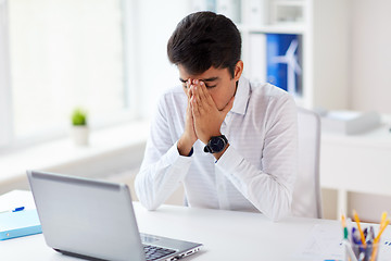 Image showing stressed businessman with laptop at office