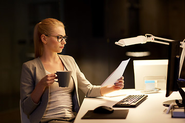 Image showing businesswoman with papers working at night office