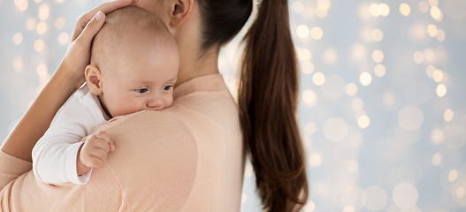 Image showing close up of little baby boy with mother over lights