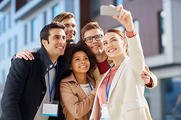 Image showing business team with conference badges taking selfie