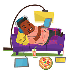 Image showing Man lying on sofa with many gadgets.