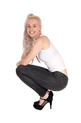 Image showing Happy blond woman crouching on floor