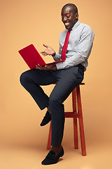 Image showing Handsome Afro American man sitting and using a laptop