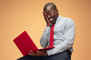 Image showing Handsome Afro American man sitting and using a laptop