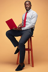 Image showing Handsome Afro American man sitting and using a laptop