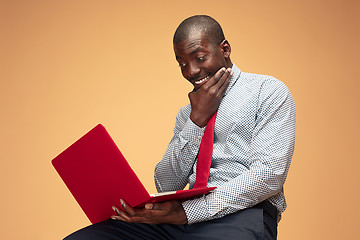 Image showing Handsome Afro American man sitting and using a laptop