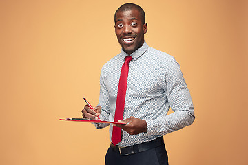 Image showing Attractive standing Afro-American businessman writing notes