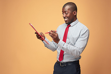 Image showing Attractive standing Afro-American businessman writing notes