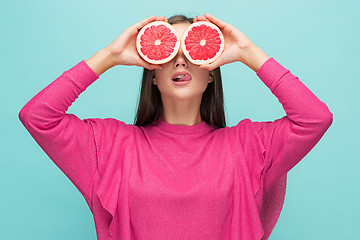 Image showing Pretty woman with delicious grapefruit in her arms.