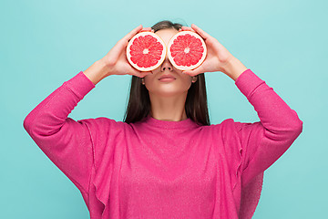 Image showing Pretty woman with delicious grapefruit in her arms.