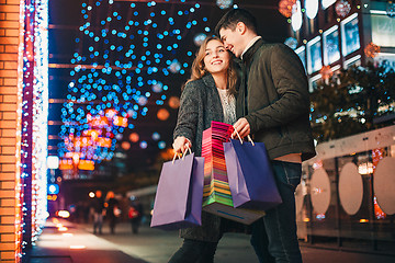 Image showing The happy couple with shopping bags enjoying night at city background