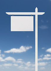 Image showing Blank Real Estate Sign Over A Blue Sky with Clouds.