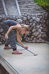 Image showing Happy little girl  playing mini golf.