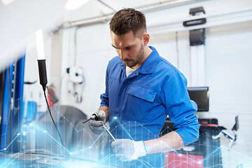 Image showing mechanic man with wrench repairing car at workshop