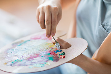 Image showing artist with palette knife painting at art studio