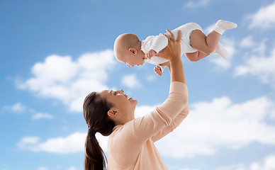 Image showing happy mother playing with little baby boy over sky