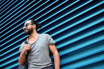 Image showing man in sunglasses with bag standing at street wall