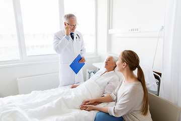 Image showing senior woman and doctor with clipboard at hospital