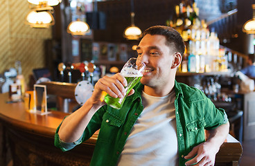 Image showing man drinking green beer at bar or pub