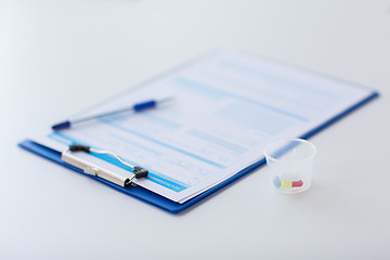 Image showing clipboard with report and drugs in medical cup