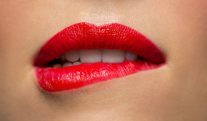 Image showing close up of woman with red lipstick biting lip