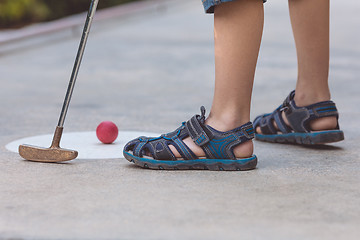 Image showing Happy little boy  playing mini golf.