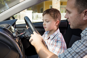 Image showing Happy father and son sitting in the car at the day time.