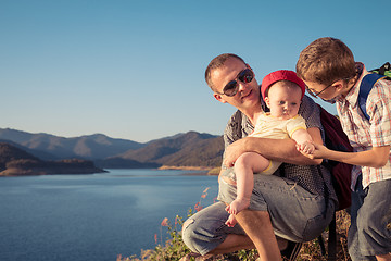 Image showing Happy family sitting near the lake at the day time.