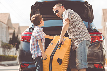 Image showing Happy father and son getting ready for road trip on a sunny day.