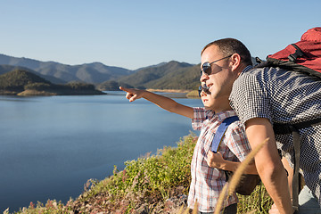 Image showing Happy family standing near a lake at the day time.